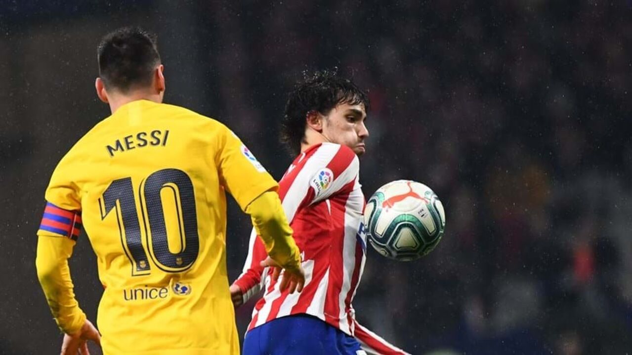 João Félix controla a bola perante o olhar atento de Messi