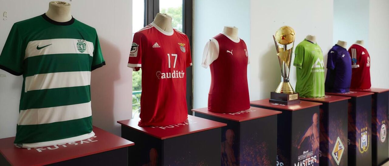 A taça da Record International Futsal Masters Portimão 2023 ao lado das camisolas dos clubes participantes
