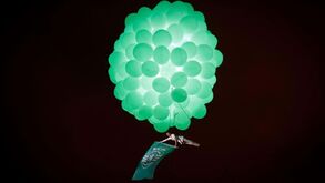 Mulher num balão de ar quente verde sobrevoa Marquês com bandeira do Sporting