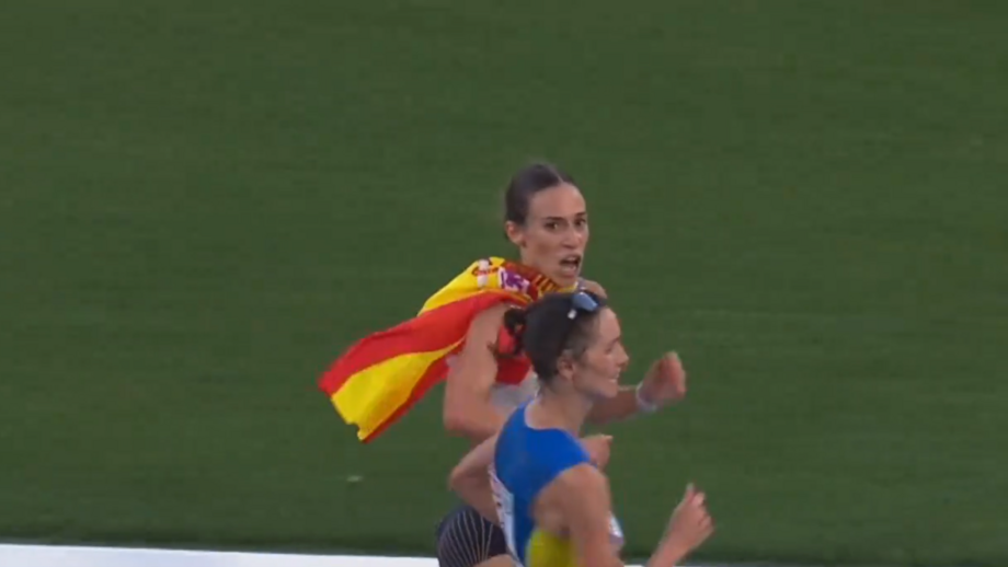 Laura García-Caro sorria, acenava e empunhava a bandeira de Espanha enquanto a ucraniana Lyudmila Olyanovska ganhava terreno