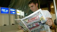 Delibasic no aeroporto a ler o Jornal Record