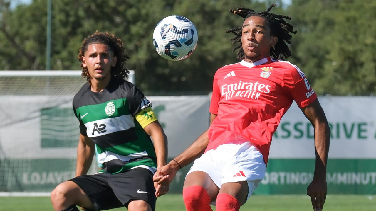Os jogadores disputam a posse da bola no relvado no decorrer do jogo