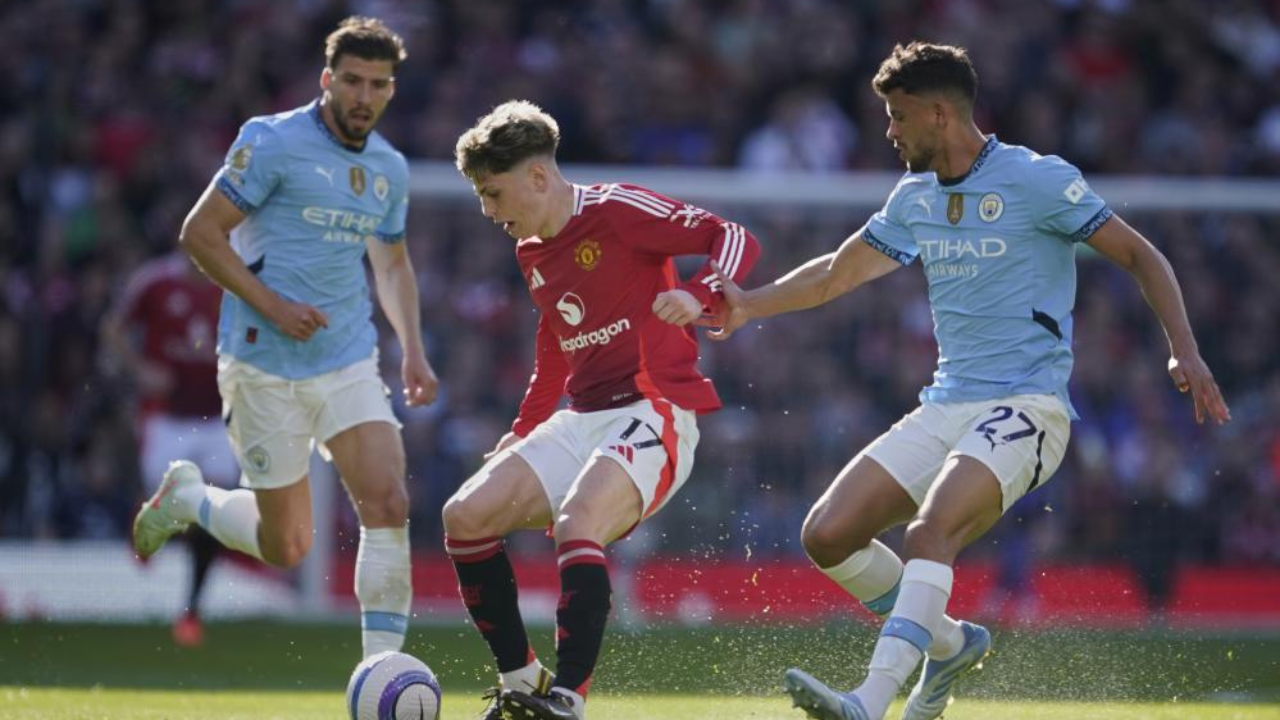 Garnacho disputa a bola com Matheus Nunes durante o dérbi entre United e City