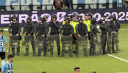Polícia de choque rodeia a equipa de arbitragem após o Grémio-Internacional
