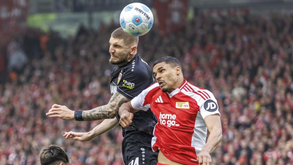 Jogadores de Union Berlim e Estugarda disputam a bola no ar