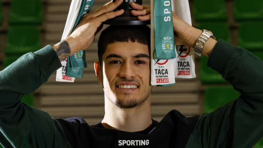 Diogo Santos, jogador de futsal do Sporting, exibe a Taça de Portugal durante a entrevista a Record