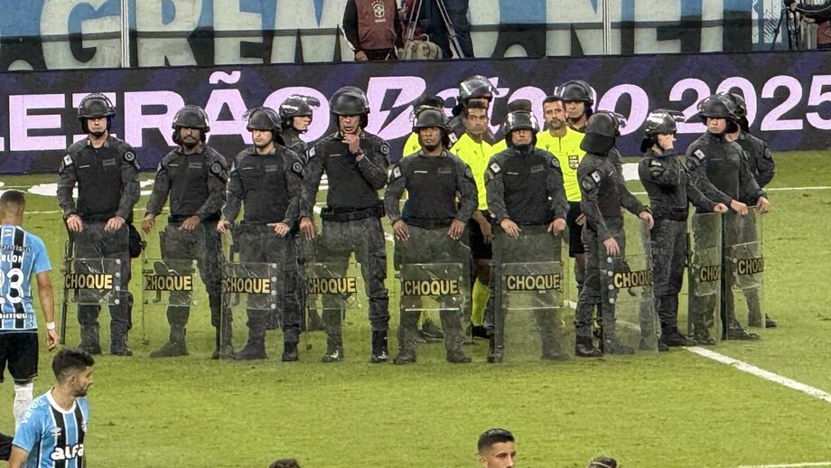 Polícia de choque rodeia a equipa de arbitragem após o Grémio-Internacional