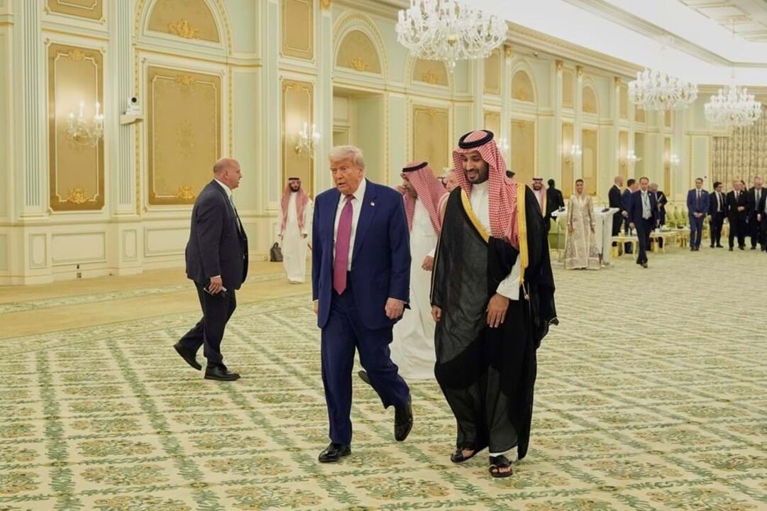 Donald Trump e o príncipe herdeiro saudita Mohammed bin Salman caminham para uma cerimónia de assinatura no Palácio Real em Riade, na Arábia Saudita