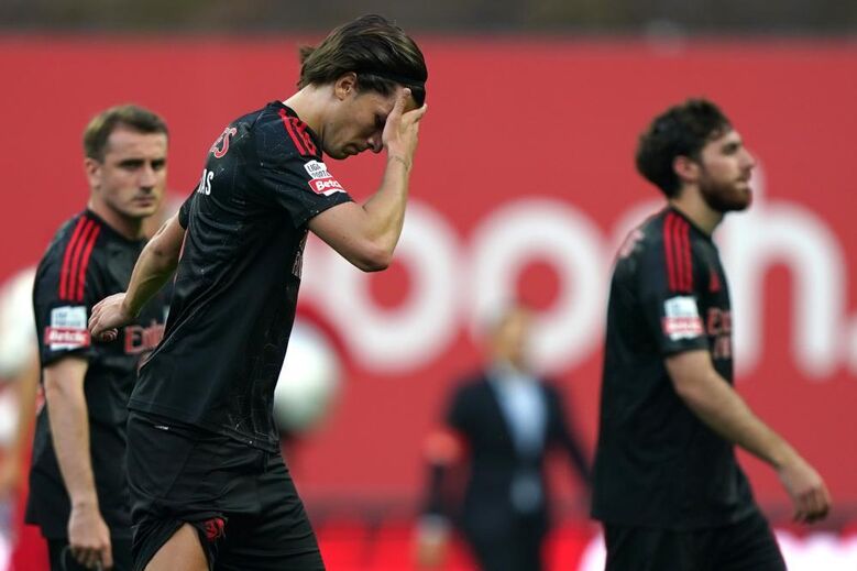 Álvaro Carreras com a mão na cabeça sob o olhar de Aktürkoglu