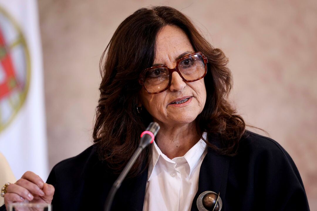 Mulher discursa ao microfone, em cerimónia oficial