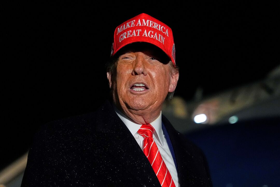 Donald Trump discursa com boné vermelho com o slogan "Make America Great Again"