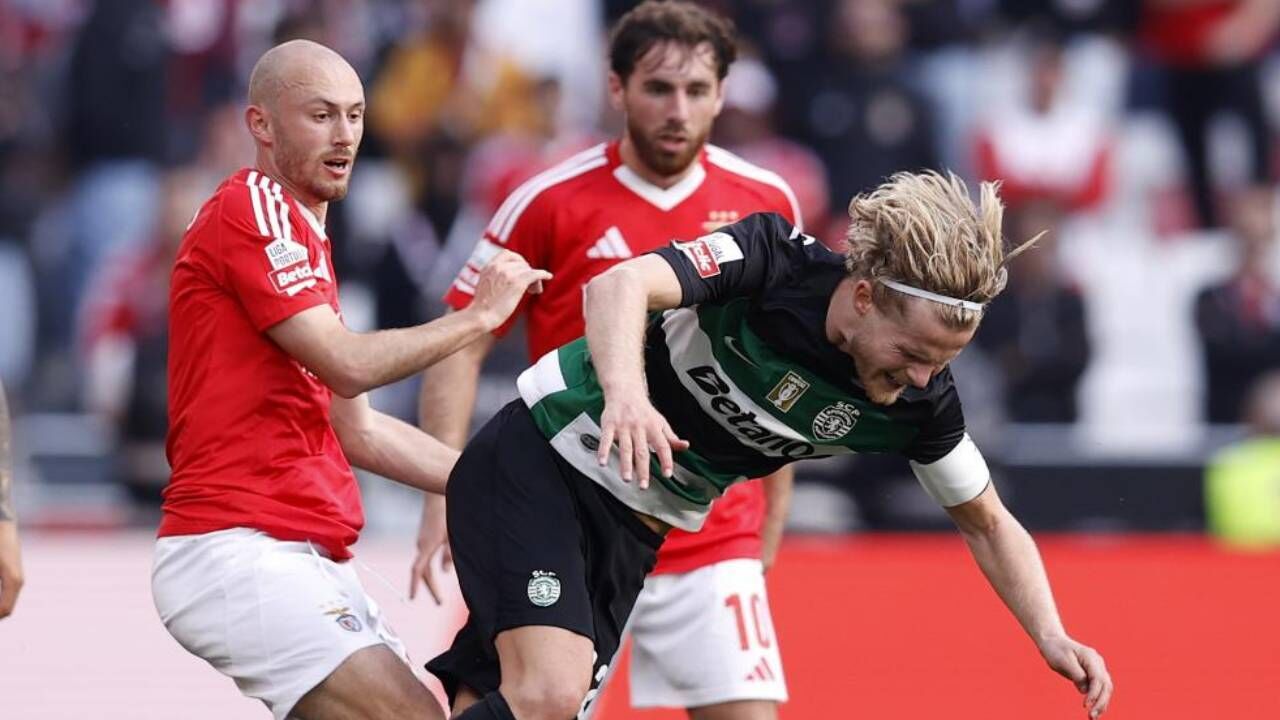 Futebolistas do Sporting e Benfica disputam a bola em jogo da Liga