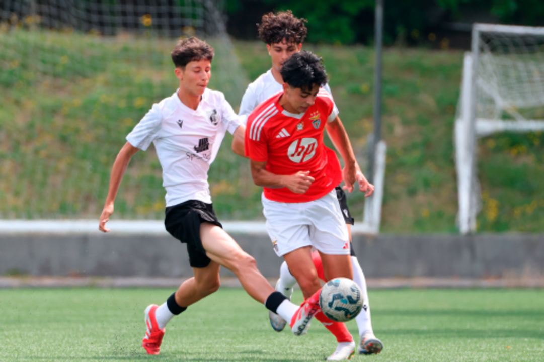 Jogo de futebol entre jovens do Benfica e adversário
