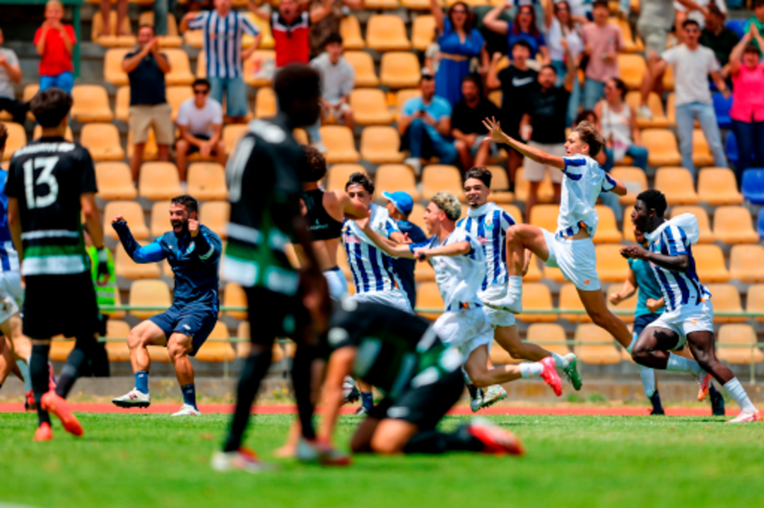 Jogadores festejam num campo de futebol com adeptos nas bancadas