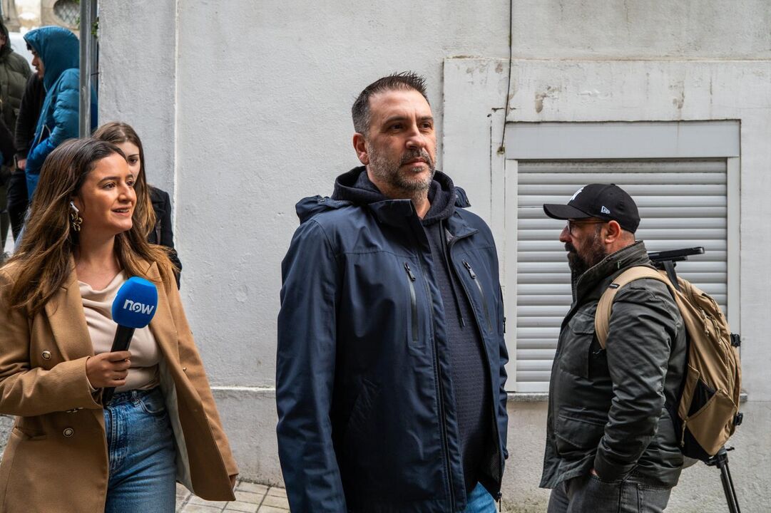 Entrevista com figura pública para a estação "NOW", com dois homens a assistir