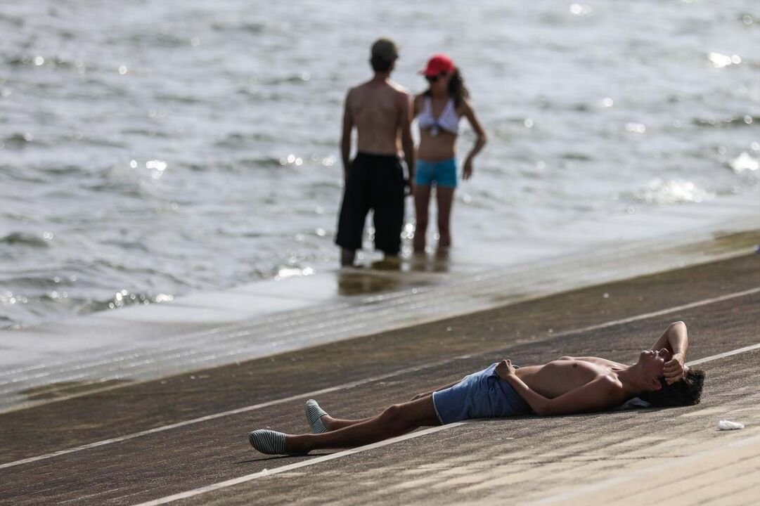 Pessoas aproveitam dia de sol à beira-mar