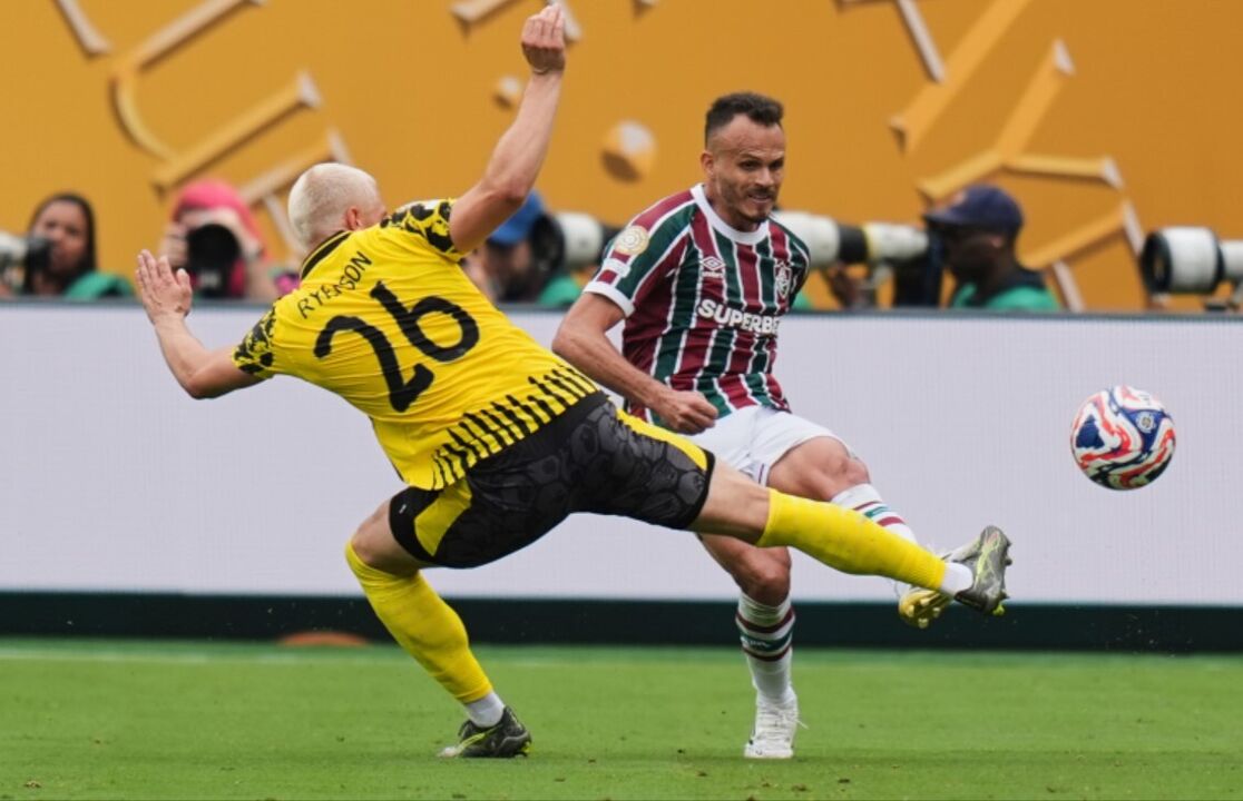 Jogo de futebol com jogadores em campo e bola em disputa
