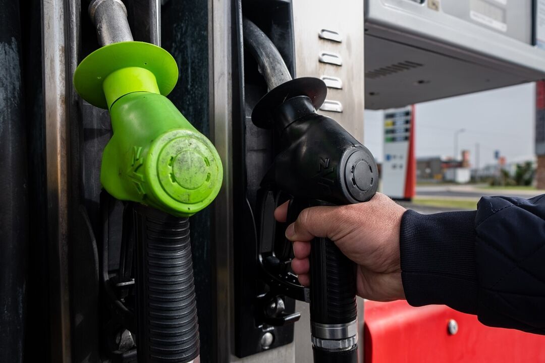 Bomba de gasolina com mangueiras verde e preta.
