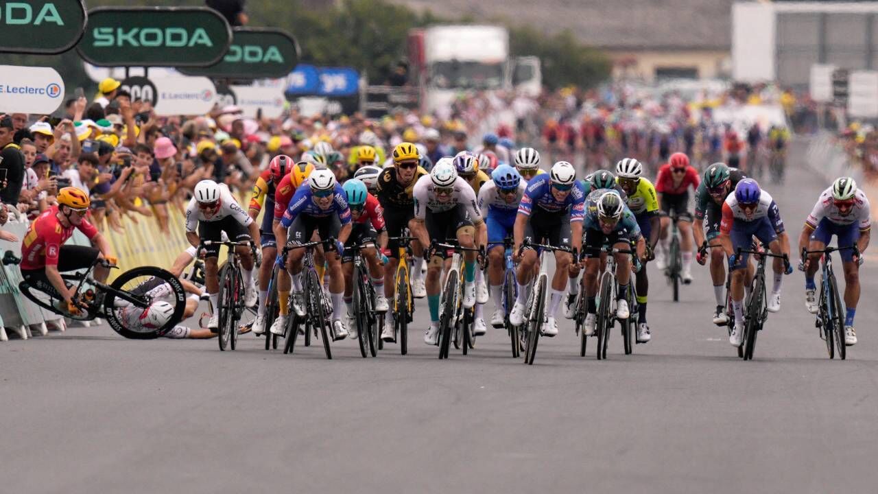 Ciclistas competem em prova; queda marca momento tenso da competição.
