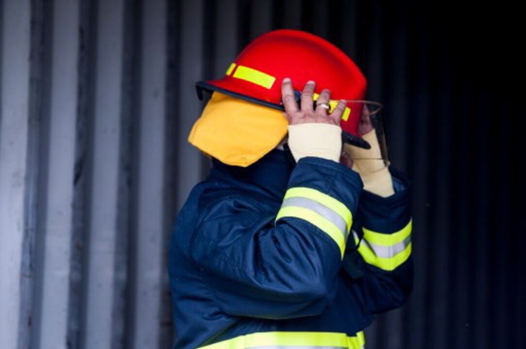 Bombeiro equipado com capacete e fato de proteção