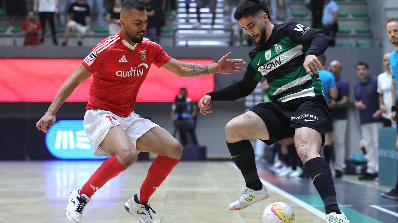 Jogadores de futsal disputam a posse de bola durante um jogo