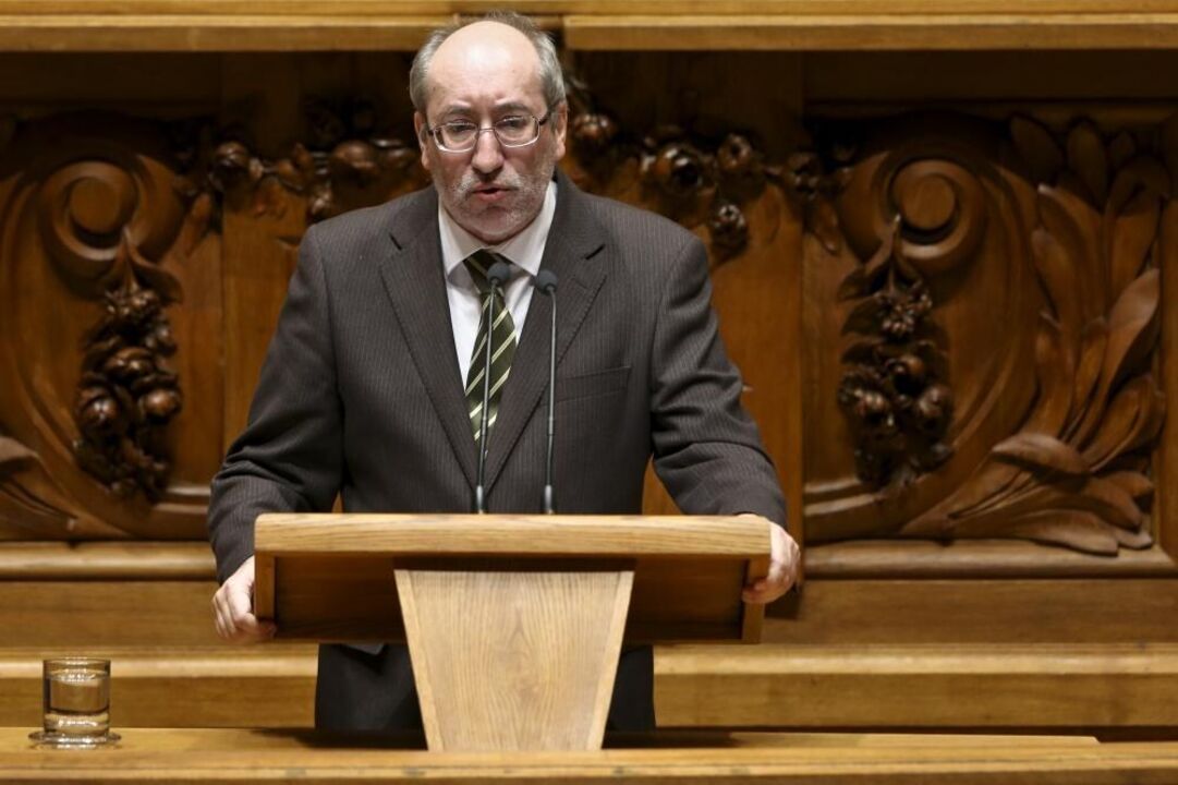 Um homem discursa num púlpito de madeira