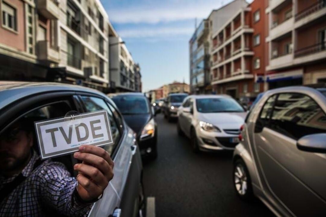 Condutor segura placa de isenção de taxa de televisão numa rua da cidade