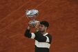Carlos Alcaraz celebra a vitória com o troféu no Court Philippe-Chatrier, em Roland Garros
