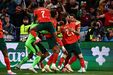 Jogadores de futebol festejam golo num jogo de seleções