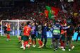 Jogadores de futebol festejam com adeptos portugueses em fundo