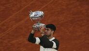 Carlos Alcaraz celebra a vitória com o troféu no Court Philippe-Chatrier, em Roland Garros