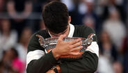 Homem abraça troféu em Roland Garros