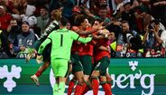 Jogadores de futebol celebram um golo com entusiasmo num jogo