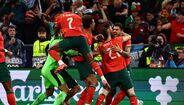 Jogadores de futebol festejam golo num jogo de seleções