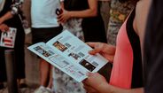 Mulher examina folheto com imagens e códigos QR em grupo