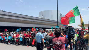 Centenas de adeptos cantam o hino no exterior do aeroporto enquanto esperam pela Seleção