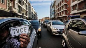 Condutor segura placa de isenção de taxa de televisão numa rua da cidade