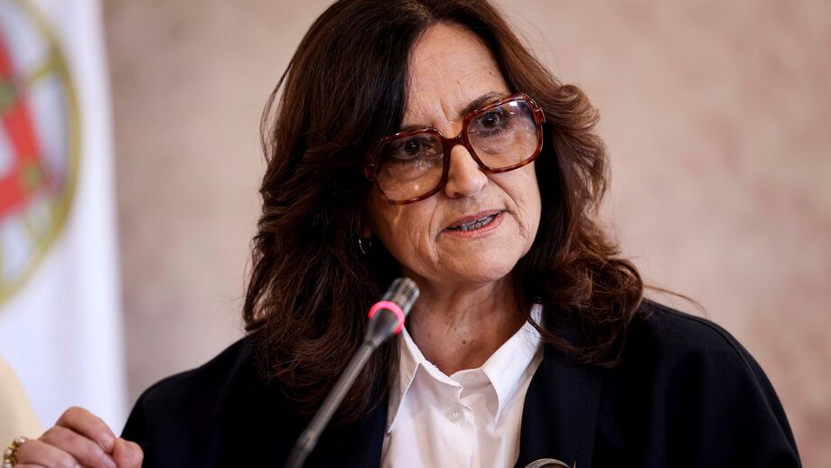 Mulher discursa ao microfone, em cerimónia oficial