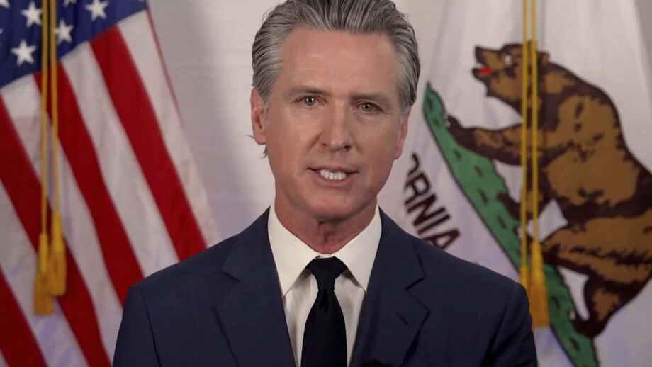 Gavin Newsom discursa com as bandeiras da Califórnia e dos EUA no fundo