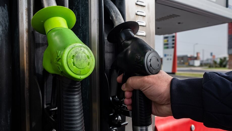 Bomba de gasolina com mangueiras verde e preta.
