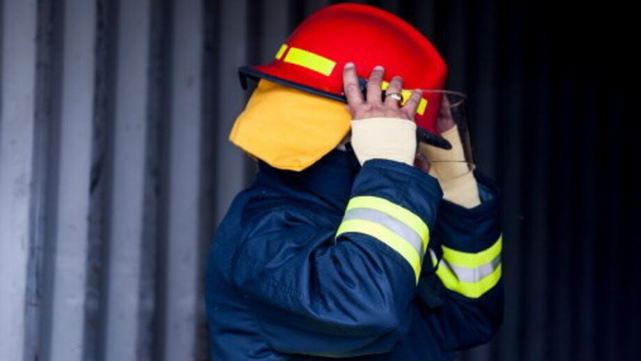 Bombeiro equipado com capacete e fato de proteção