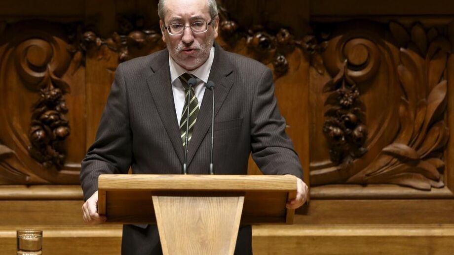 Um homem discursa num púlpito de madeira