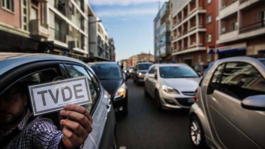 Condutor segura placa de isenção de taxa de televisão numa rua da cidade