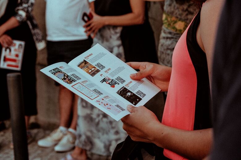 Mulher examina folheto com imagens e códigos QR em grupo