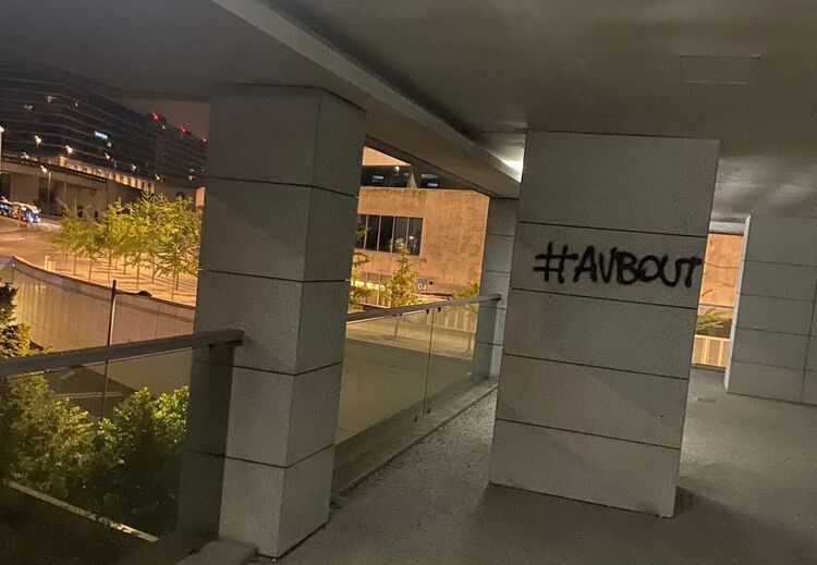 Grafíti com a hashtag #AVBOUT numa estrutura de betão num espaço urbano