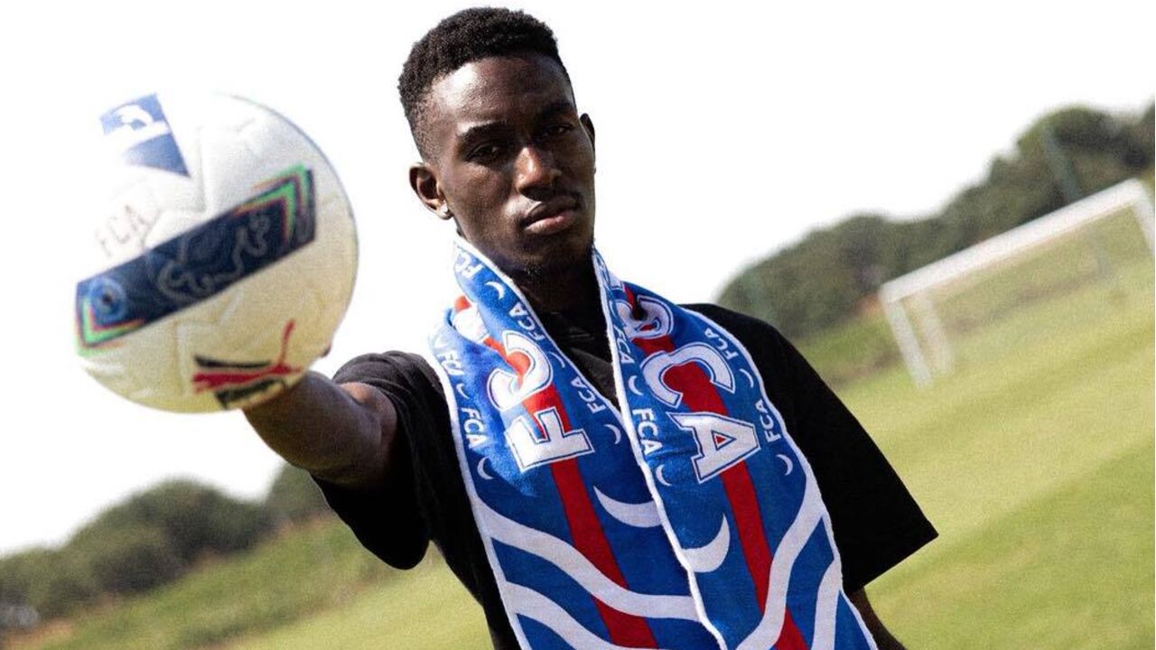 Jogador de futebol exibe cachecol do clube