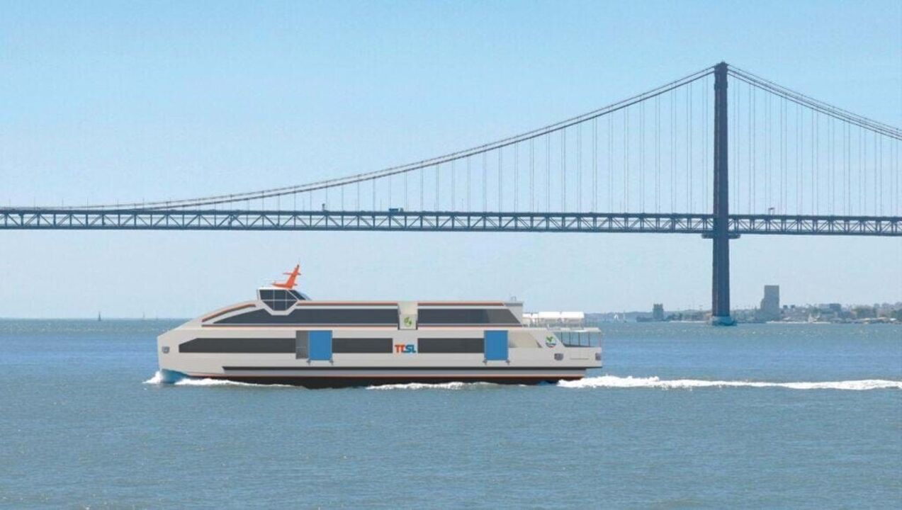 Ferry elétrico da Transtejo-Soflusa navega no Tejo, com a Ponte 25 de Abril ao fundo