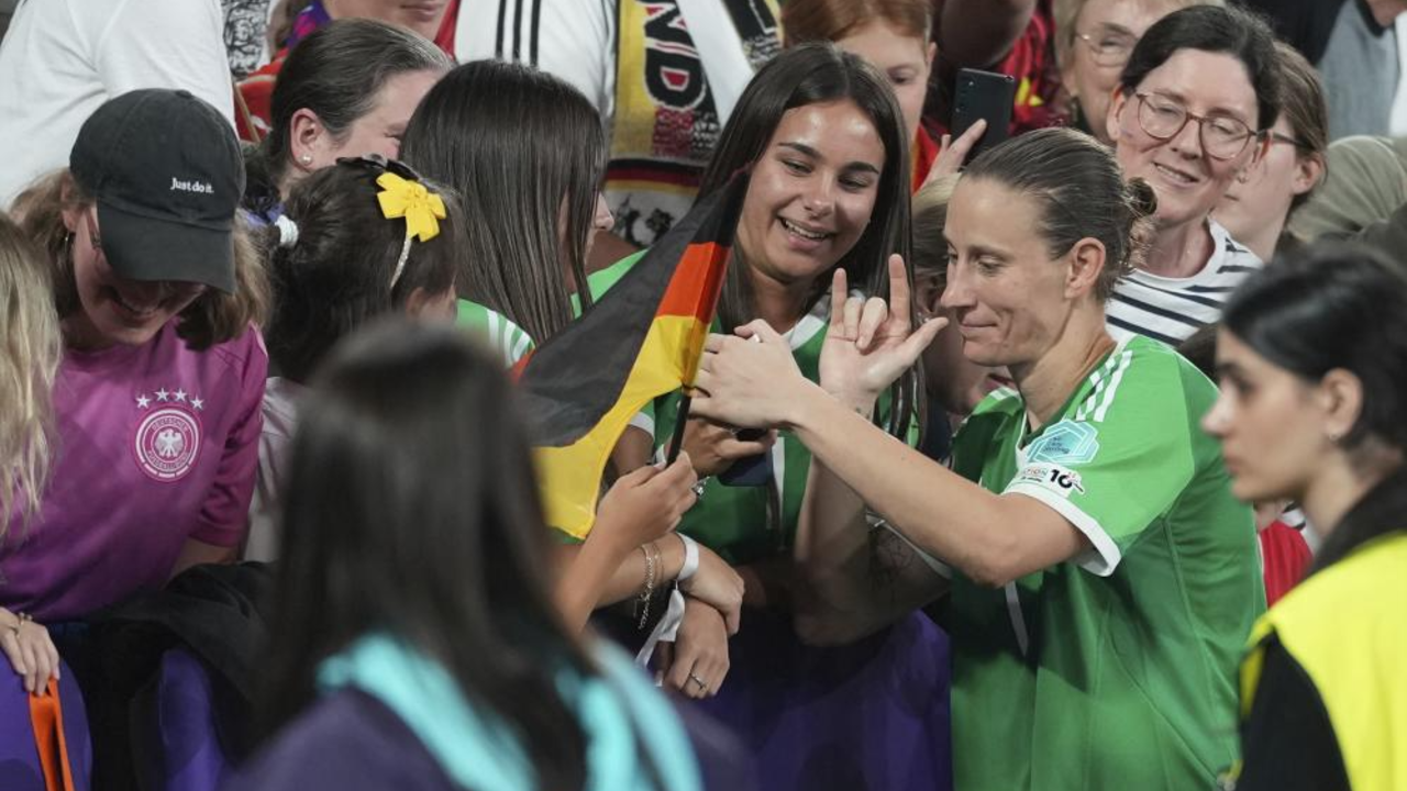 Ann-Katrin Berger interage com adeptos e exibe bandeira da Alemanha