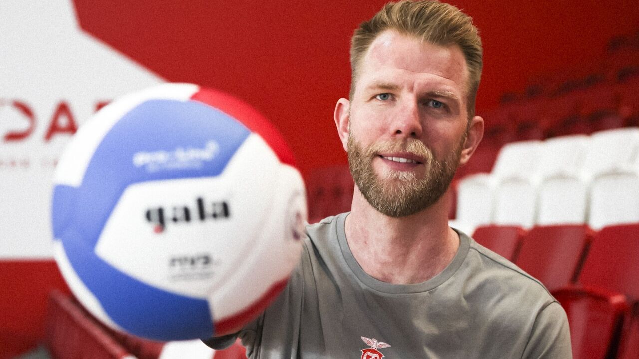 Atleta de voleibol do Benfica sorri com a bola