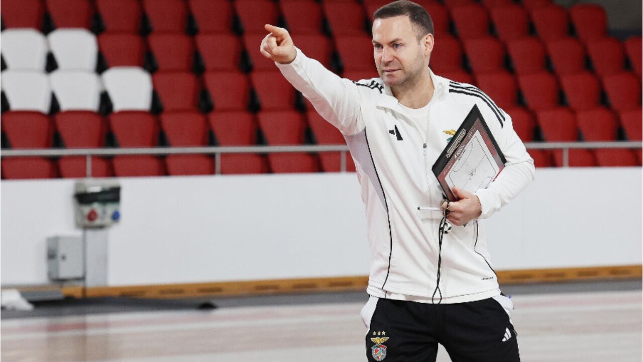 O treinador do Benfica gesticula com uma prancheta na mão